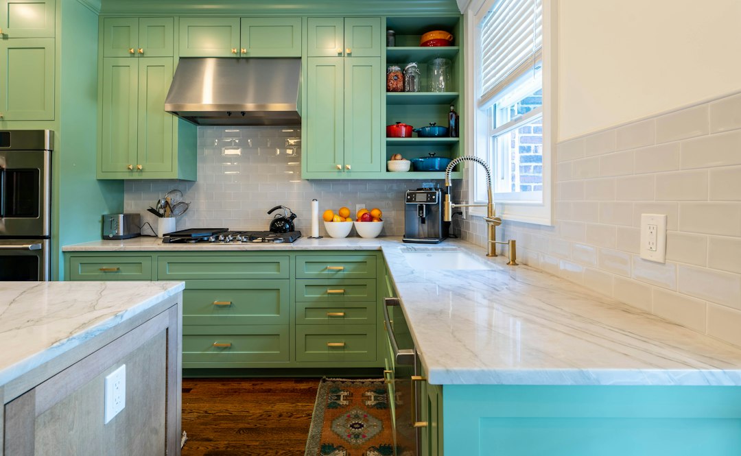 A kitchen with green cabinets and marble counter tops in Riverside, CA