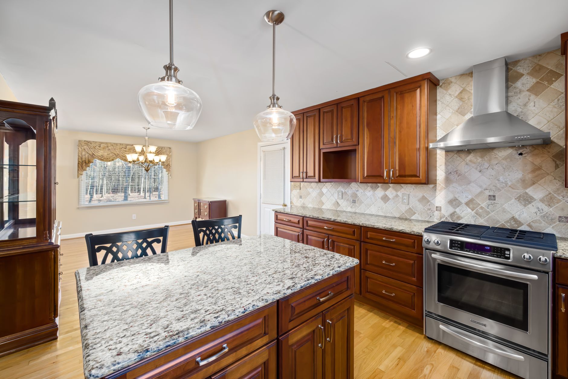 Spacious modern kitchen featuring granite countertops and wooden cabinets in Riverside, CA