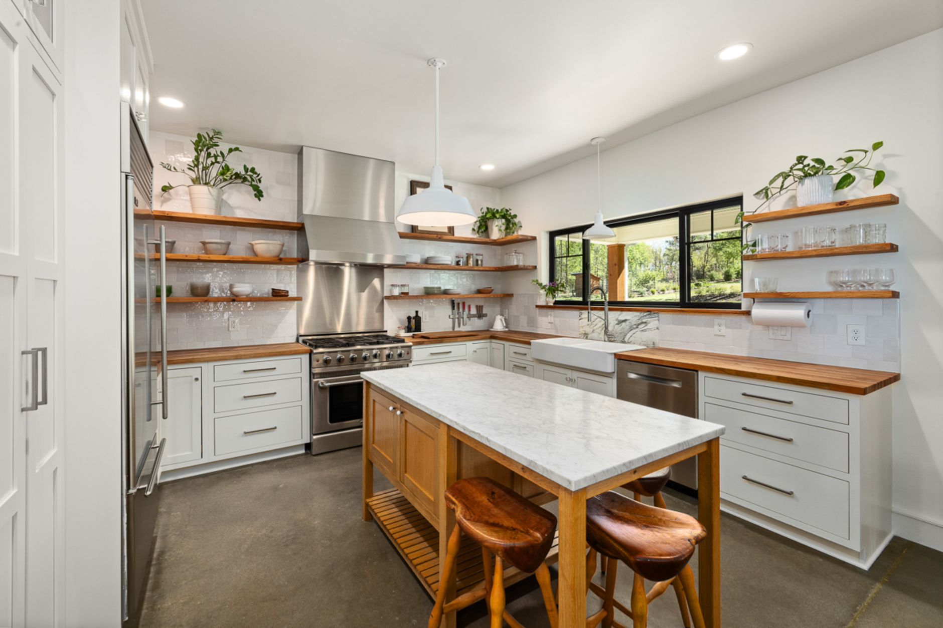 Bright modern kitchen with wooden accents, open shelves, and marble countertop in Riverside, CA