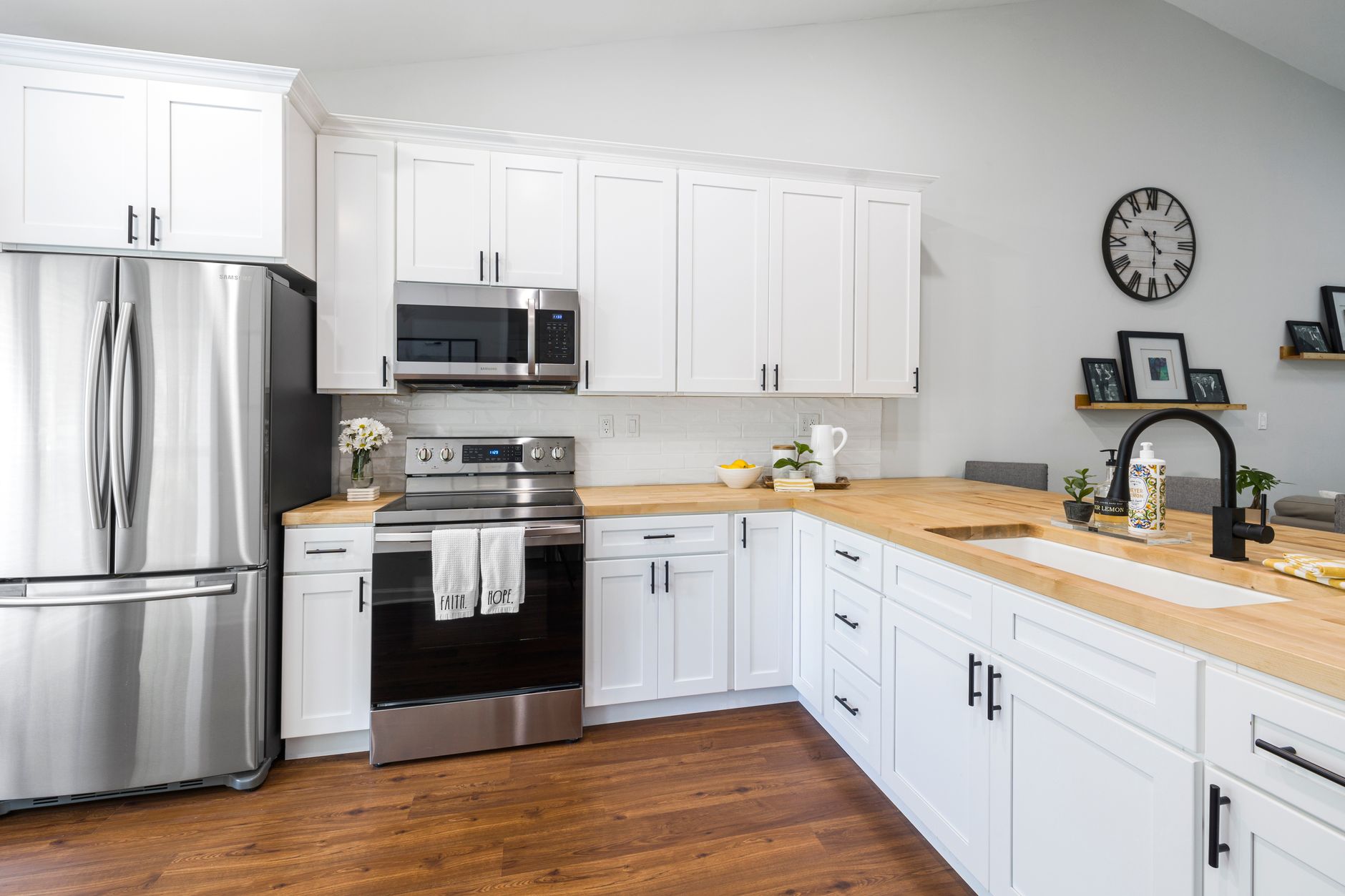Bright and spacious white kitchen with modern appliances, wooden countertops, and elegant decor in Riverside, CA